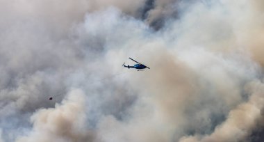 Sıcak bir yaz günü, Hope yakınlarındaki dağda, BC Orman Yangını ve Dumanı 'nın üzerinde uçan Wildfire Servis Helikopteri. British Columbia, Kanada. Doğal Felaket