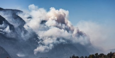 BC Orman Ateşi ve Duman, sıcak ve güneşli bir yaz gününde Umut 'un yakınındaki dağın üzerinde. British Columbia, Kanada. Vahşi yangın doğal afet