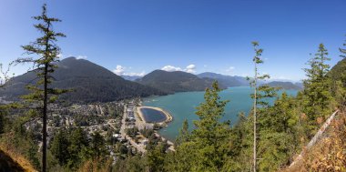Kanada Dağ Manzarası ile gölün kenarındaki küçük turistik kasabanın panoramik manzarası. Güneşli bir yaz günü. Harrison Kaplıcaları, British Columbia, Kanada. Panorama
