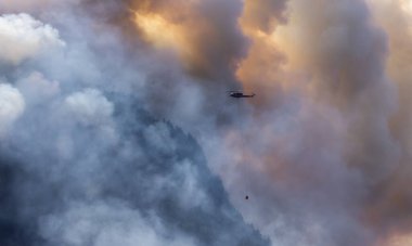 Sıcak bir yaz günü, Hope yakınlarındaki dağda, BC Orman Yangını ve Dumanı 'nın üzerinde uçan Wildfire Servis Helikopteri. British Columbia, Kanada. Doğal Felaket