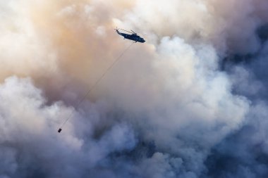 Sıcak bir yaz günü, Hope yakınlarındaki dağda, BC Orman Yangını ve Dumanı 'nın üzerinde uçan Wildfire Servis Helikopteri. British Columbia, Kanada. Doğal Felaket