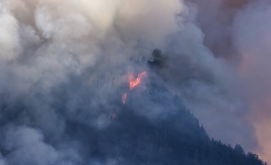 BC Orman Ateşi ve Duman, sıcak ve güneşli bir yaz gününde Umut 'un yakınındaki dağın üzerinde. British Columbia, Kanada. Vahşi yangın doğal afet