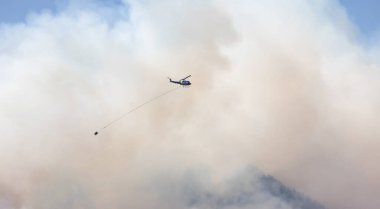 Sıcak bir yaz günü, Hope yakınlarındaki dağda, BC Orman Yangını ve Dumanı 'nın üzerinde uçan Wildfire Servis Helikopteri. British Columbia, Kanada. Doğal Felaket
