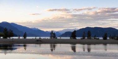 Kanada Dağ manzaralı göl kıyısında küçük bir turistik kasaba. Güneşli Yaz Günbatımı Gökyüzü. Harrison Kaplıcaları, British Columbia, Kanada.