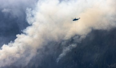 Sıcak bir yaz günü, Hope yakınlarındaki dağda, BC Orman Yangını ve Dumanı 'nın üzerinde uçan Wildfire Servis Helikopteri. British Columbia, Kanada. Doğal Felaket