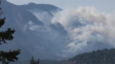 BC Orman Ateşi ve Duman, sıcak ve güneşli bir yaz gününde Umut 'un yakınındaki dağın üzerinde. British Columbia, Kanada. Vahşi ateş doğal felaket. Yavaş Hareket