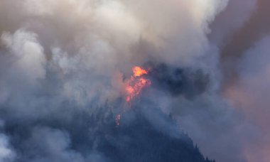BC Orman Ateşi ve Duman, sıcak ve güneşli bir yaz gününde Umut 'un yakınındaki dağın üzerinde. British Columbia, Kanada. Vahşi yangın doğal afet