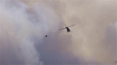 Sıcak bir yaz günü, Hope yakınlarındaki dağda, BC Orman Yangını ve Dumanı 'nın üzerinde uçan Wildfire Servis Helikopteri. British Columbia, Kanada. Doğal bir felaket. Yavaş Hareket