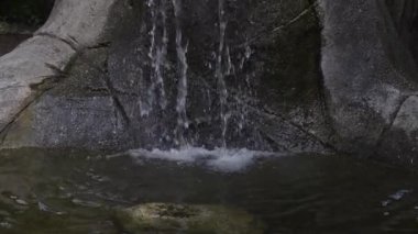 Şehir parkında kayalıklardan akan küçük şelale. Büyük Vancouver, British Columbia, Kanada. Yavaş Hareket