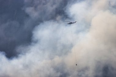 Sıcak bir yaz günü, Hope yakınlarındaki dağda, BC Orman Yangını ve Dumanı 'nın üzerinde uçan Wildfire Servis Helikopteri. British Columbia, Kanada. Doğal Felaket
