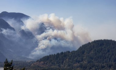 BC Orman Ateşi ve Duman, sıcak ve güneşli bir yaz gününde Umut 'un yakınındaki dağın üzerinde. British Columbia, Kanada. Vahşi yangın doğal afet