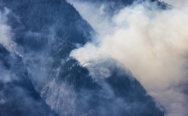 BC Orman Ateşi ve Duman, sıcak ve güneşli bir yaz gününde Umut 'un yakınındaki dağın üzerinde. British Columbia, Kanada. Vahşi yangın doğal afet