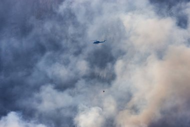 Sıcak bir yaz günü, Hope yakınlarındaki dağda, BC Orman Yangını ve Dumanı 'nın üzerinde uçan Wildfire Servis Helikopteri. British Columbia, Kanada. Doğal Felaket