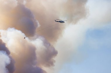 Sıcak bir yaz günü, Hope yakınlarındaki dağda, BC Orman Yangını ve Dumanı 'nın üzerinde uçan Wildfire Servis Helikopteri. British Columbia, Kanada. Doğal Felaket