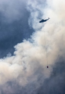 Sıcak bir yaz günü, Hope yakınlarındaki dağda, BC Orman Yangını ve Dumanı 'nın üzerinde uçan Wildfire Servis Helikopteri. British Columbia, Kanada. Doğal Felaket