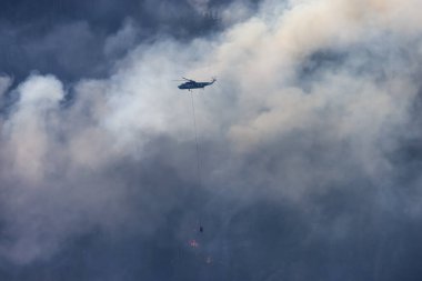 Sıcak bir yaz günü, Hope yakınlarındaki dağda, BC Orman Yangını ve Dumanı 'nın üzerinde uçan Wildfire Servis Helikopteri. British Columbia, Kanada. Doğal Felaket