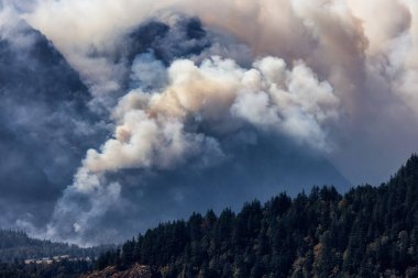BC Orman Ateşi ve Duman, sıcak ve güneşli bir yaz gününde Umut 'un yakınındaki dağın üzerinde. British Columbia, Kanada. Vahşi yangın doğal afet