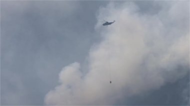 Sıcak bir yaz günü, Hope yakınlarındaki dağda, BC Orman Yangını ve Dumanı 'nın üzerinde uçan Wildfire Servis Helikopteri. British Columbia, Kanada. Doğal bir felaket. Yavaş Hareket