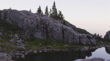 Kanada Dağları 'nın tepesinde, göl ve canlı yeşil ağaçlar. Güneşli Günbatımı Gökyüzü. Vancouver, British Columbia, Kanada yakınlarındaki Seymour Dağı 'nın tepesinde. Doğa Arkaplanı