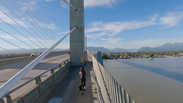 骑自行车的妇女骑着自行车走过弗拉瑟河上的金耳桥 加拿大不列颠哥伦比亚省大温哥华Langley的Pitt Meadows 高质量的4K镜头 — 图库视频影像