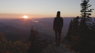 Güneşli günbatımında Sonbahar Renkleri ile Kanada Manzarasında Maceracı Kadın Yürüyüşü. Elk Dağı, Chilliwack, Vancouver 'ın doğusu, British Columbia, Kanada. Macera Yolculuğu Konsepti. Yavaş Hareket