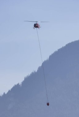 Sıcak bir yaz günü, Hope yakınlarındaki dağda, BC Orman Yangını ve Dumanı 'nın üzerinde uçan Wildfire Servis Helikopteri. British Columbia, Kanada. Doğal Felaket