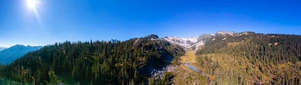 Aerial Panoramic View of River with green trees in Canadian Mountain Landscape. Brandywine Meadows near Whistler and Squamish, British Columbia, Canada. Nature Background Panorama