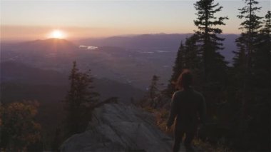 Güneşli günbatımında Sonbahar Renkleri ile Kanada Manzarasında Maceracı Kadın Yürüyüşü. Elk Dağı, Chilliwack, Vancouver 'ın doğusu, British Columbia, Kanada. Macera Yolculuğu Konsepti. Yavaş Hareket