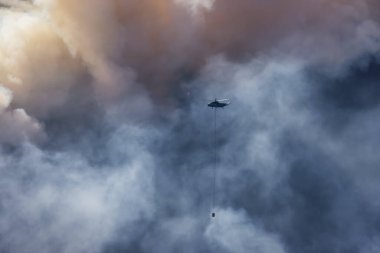 Sıcak bir yaz günü, Hope yakınlarındaki dağda, BC Orman Yangını ve Dumanı 'nın üzerinde uçan Wildfire Servis Helikopteri. British Columbia, Kanada. Doğal Felaket