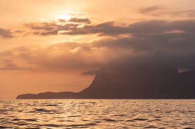 Rio de Janeiro, Brezilya üzerinde okyanustan turuncu günbatımı bulutlarına güzel bir manzara