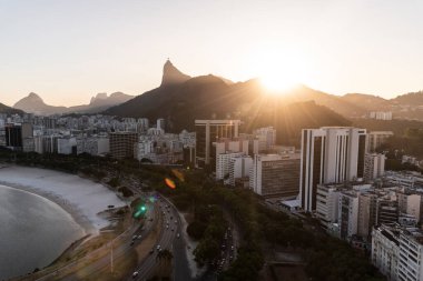 Şehir plajına, binalara ve dağlara, Rio de Janeiro, Brezilya 'ya güzel gün batımı manzarası