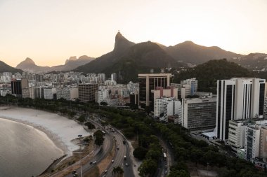 Şehir plajına, binalara ve dağlara, Rio de Janeiro, Brezilya 'ya güzel gün batımı manzarası