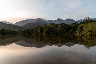 Beautiful view to sunset over lake and rainforest mountains, countryside of Rio de Janeiro State, Brazil