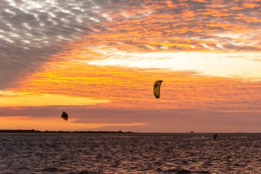 Beautiful view to kitesurfers and golden sunset clouds in Atins Beach, Lenis Maranhenses, Maranho State, Brazil.