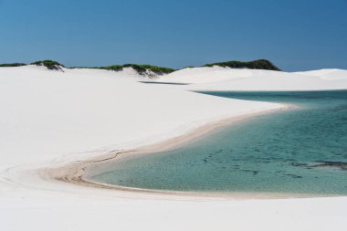 Beautiful view to blue rainwater lagoon and white sand dunes in Lenis Maranhenses, Maranho State, Brazil.