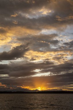 Beautiful sunset view to orange clouds and water in Parnaiba River Delta, Maranho State, Brazil.