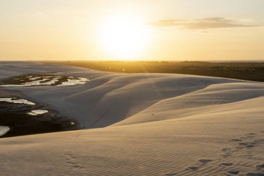 Beautiful sunset view to rain water lake and white sand dunes in Lenis Maranhenses, Maranho State, Brazil.