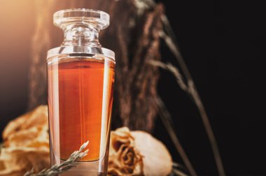 Kuru çiçek ve ahşap bir arka planda şişedeki kadın parfümü..