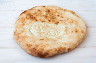Beyaz ahşap masada susam tohumlu buğday tortilla.