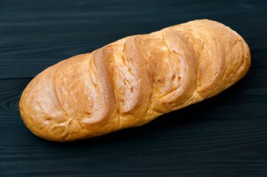 Buğday ekmeği beyaz siyah ahşap masada.