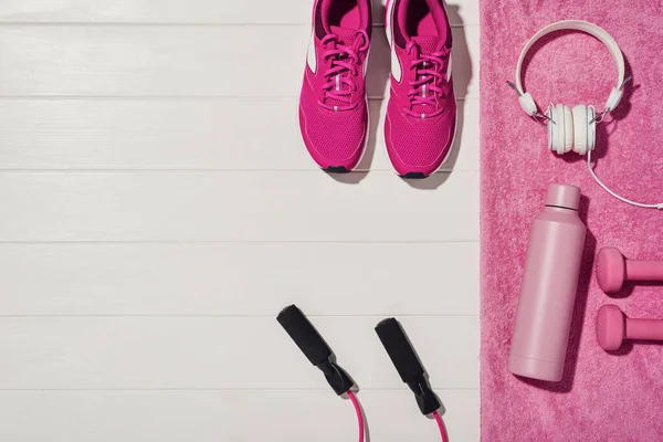 Beyaz ahşap döşeme arka planında fitness ya da vücut geliştirme kavramı. Evde antrenman için spor malzemeleri. Fotoğraf yukarıdan çekilmiş, üst görünümde bir sürü kopya alanı var