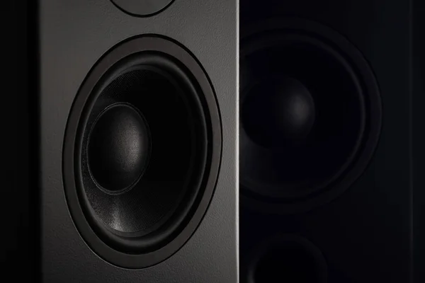 Stereo sound speakers closeup on black background with copy space. Contrast, accent lighting from the side