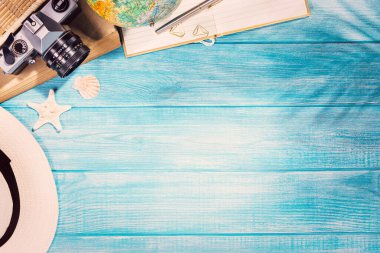 Deniz mavisi iskeledeki yaz plajı aksesuarlarının en üst görüntüsü. Kopyalama alanı ve görünür ahşap dokusu olan arkaplan.