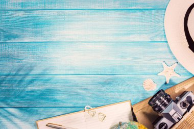 Deniz mavisi iskeledeki yaz plajı aksesuarlarının en üst görüntüsü. Kopyalama alanı ve görünür ahşap dokusu olan arkaplan.