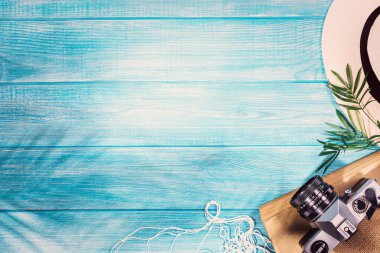 Deniz mavisi iskeledeki yaz plajı aksesuarlarının en üst görüntüsü. Kopyalama alanı ve görünür ahşap dokusu olan arkaplan.