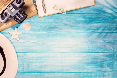 Deniz mavisi iskeledeki yaz plajı aksesuarlarının en üst görüntüsü. Kopyalama alanı ve görünür ahşap dokusu olan arkaplan.