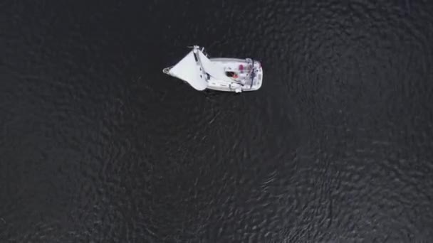 Straight down birds eye view from drone on Sailing yacht on dark blue water. — Stock Video