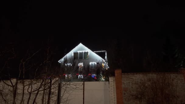 Casa de aldeia decorada para o Natal. Luzes de Natal fora em uma casa. — Vídeo de Stock