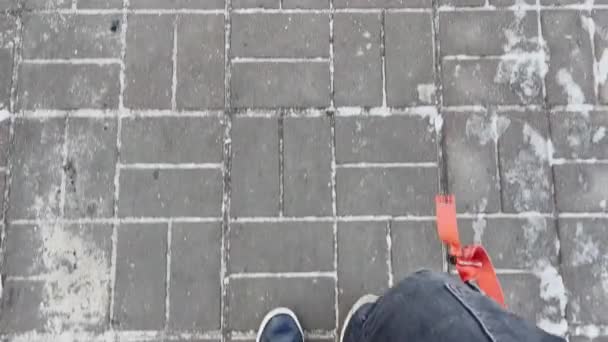 Man met zwarte sneakers loopt op een winterdag door de straat. Pov. Langzame beweging — Stockvideo