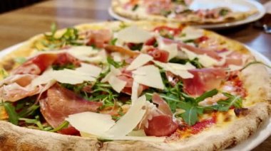 Parmesan peynirli ve roka yapraklı jambonlu pizza. Lezzetli İtalyan pizzası, yiyecek ve içecek. Yakın çekim..
